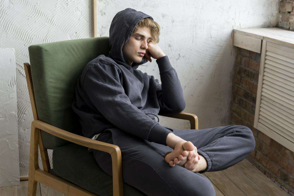 Хлопець сидить у кріслі