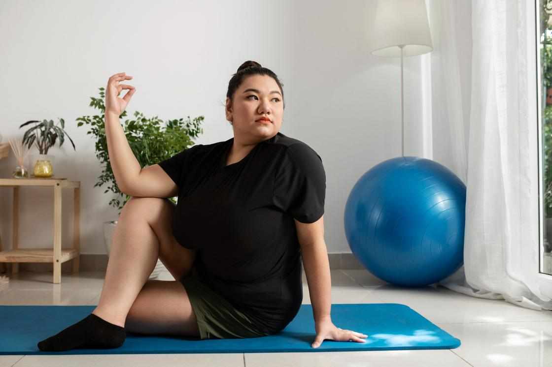Повна жінка займається йогою